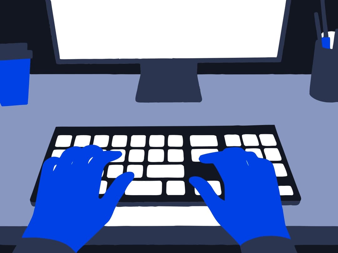 A pair of hands working on a computer keyboard in a modern office